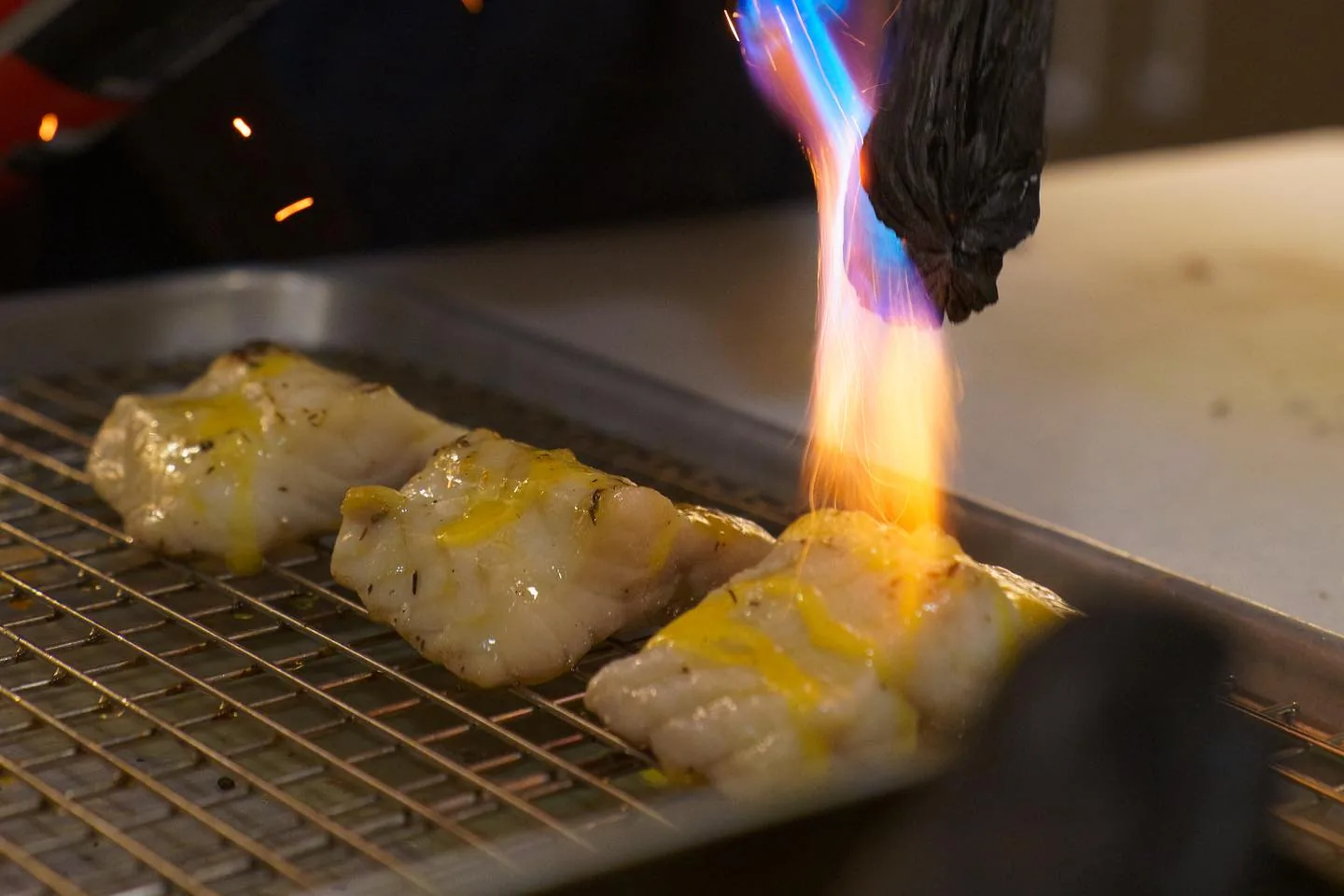 Fish under a blowtorch on a rack